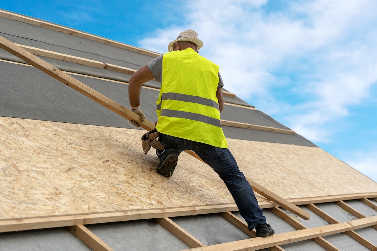  installing wooden plank on rooftop of new modern house