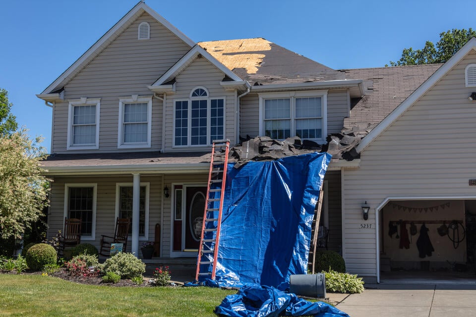 does a new roof increase home value-vinyl sided house getting a new roof installed with blue tarp and ladder being used on front of house