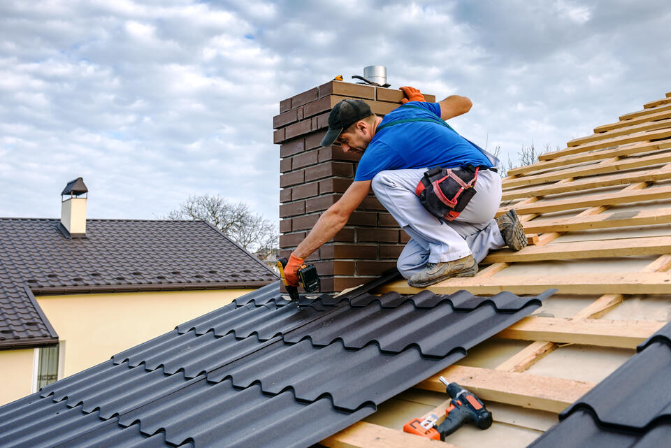 metal roof installation-roofer installing metal shingles around chimney