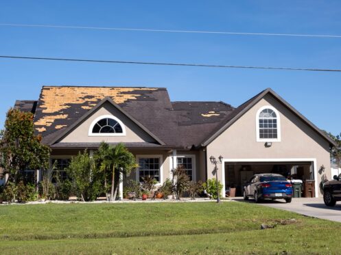 Damaged house roof with missing shingles