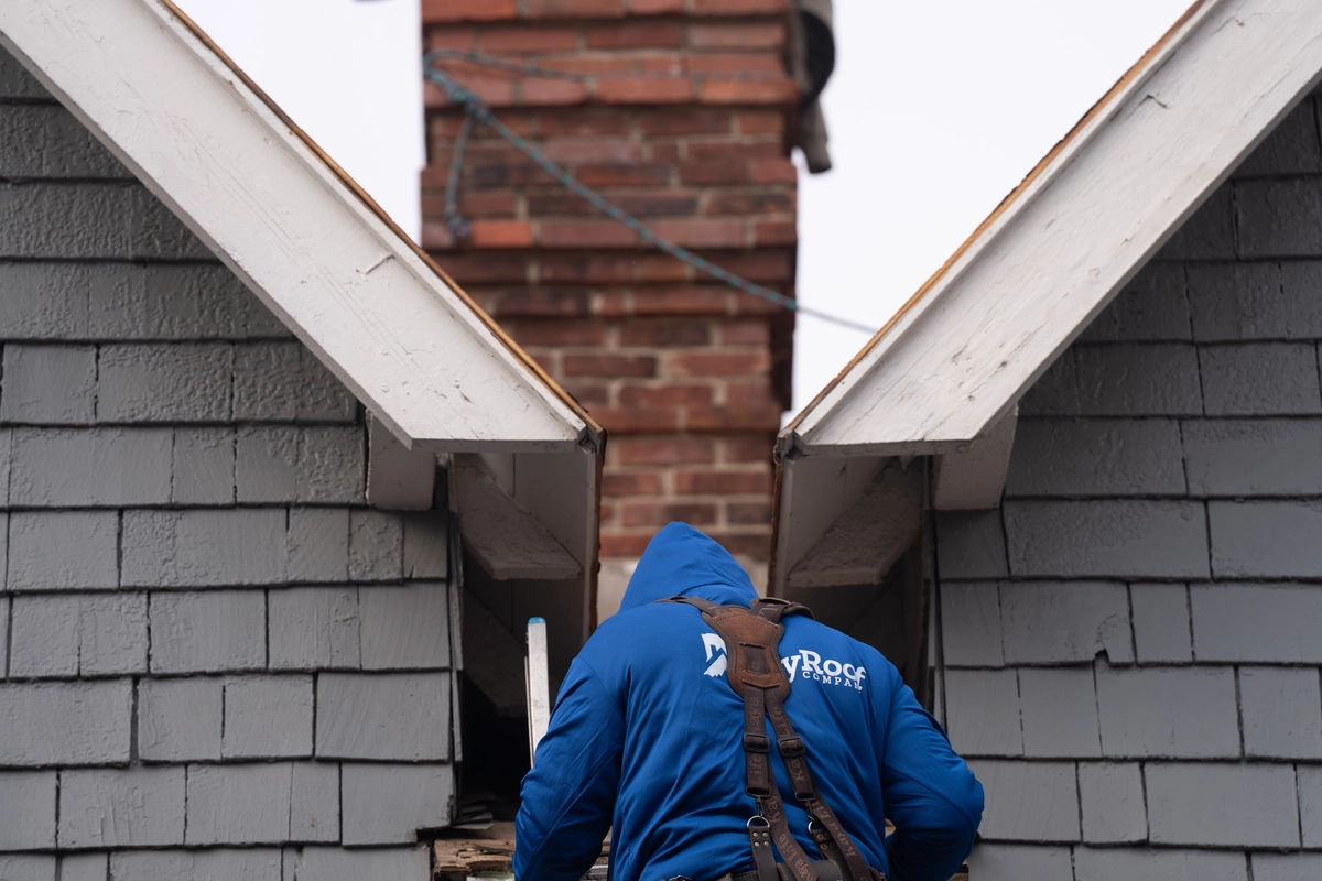 indy roof & restoration worker climbing down a ladder